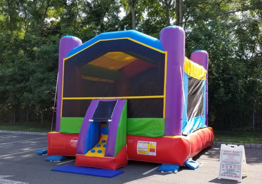 A colorful inflatable bounce house with slide.