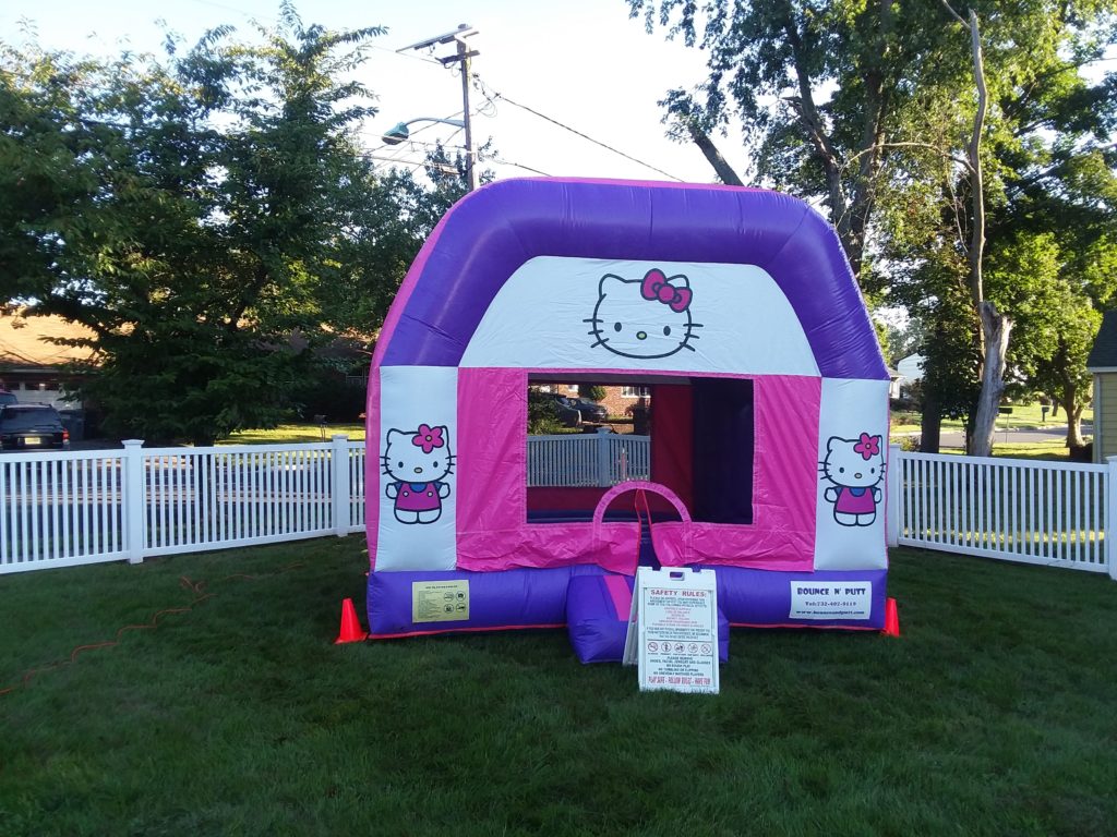 A hello kitty bouncy house in the middle of a yard.