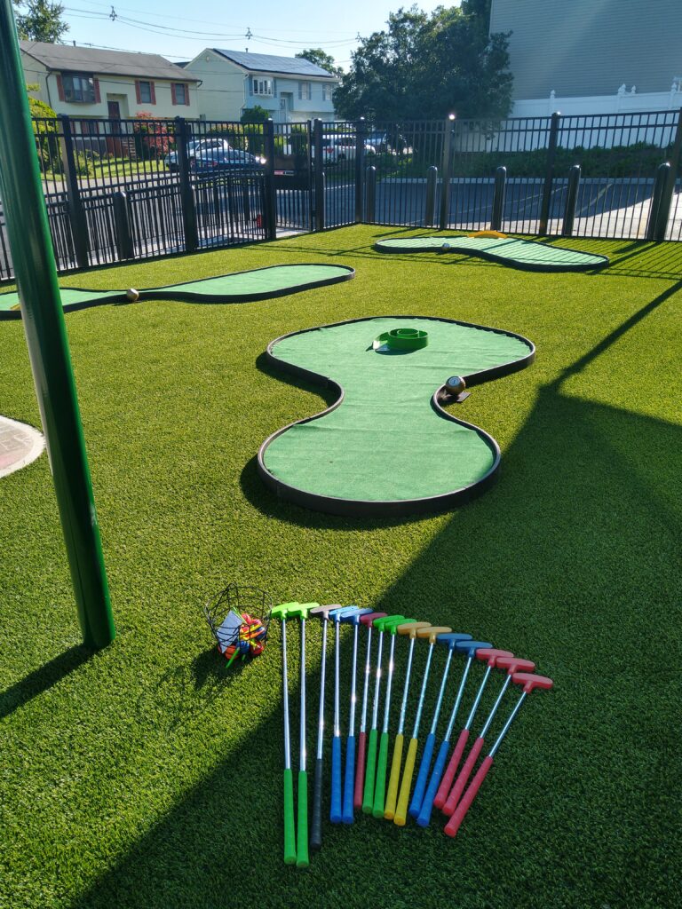 A miniature golf course with a set of tees and balls.